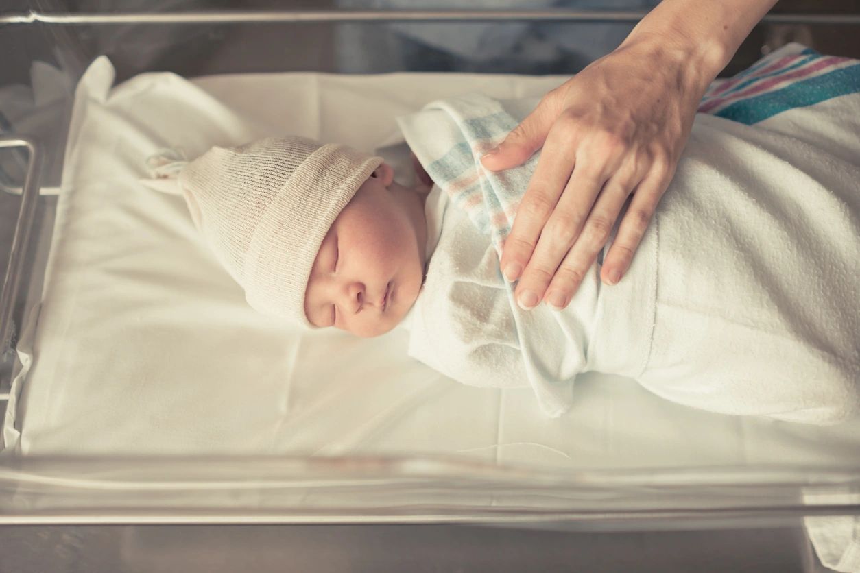 Newborn child swaddled in a blanket at the hospital