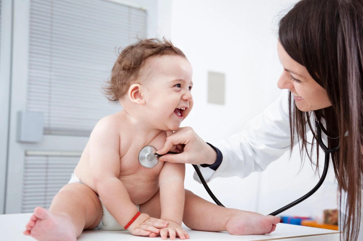 Pediatric doctor listing to a infant's heart
